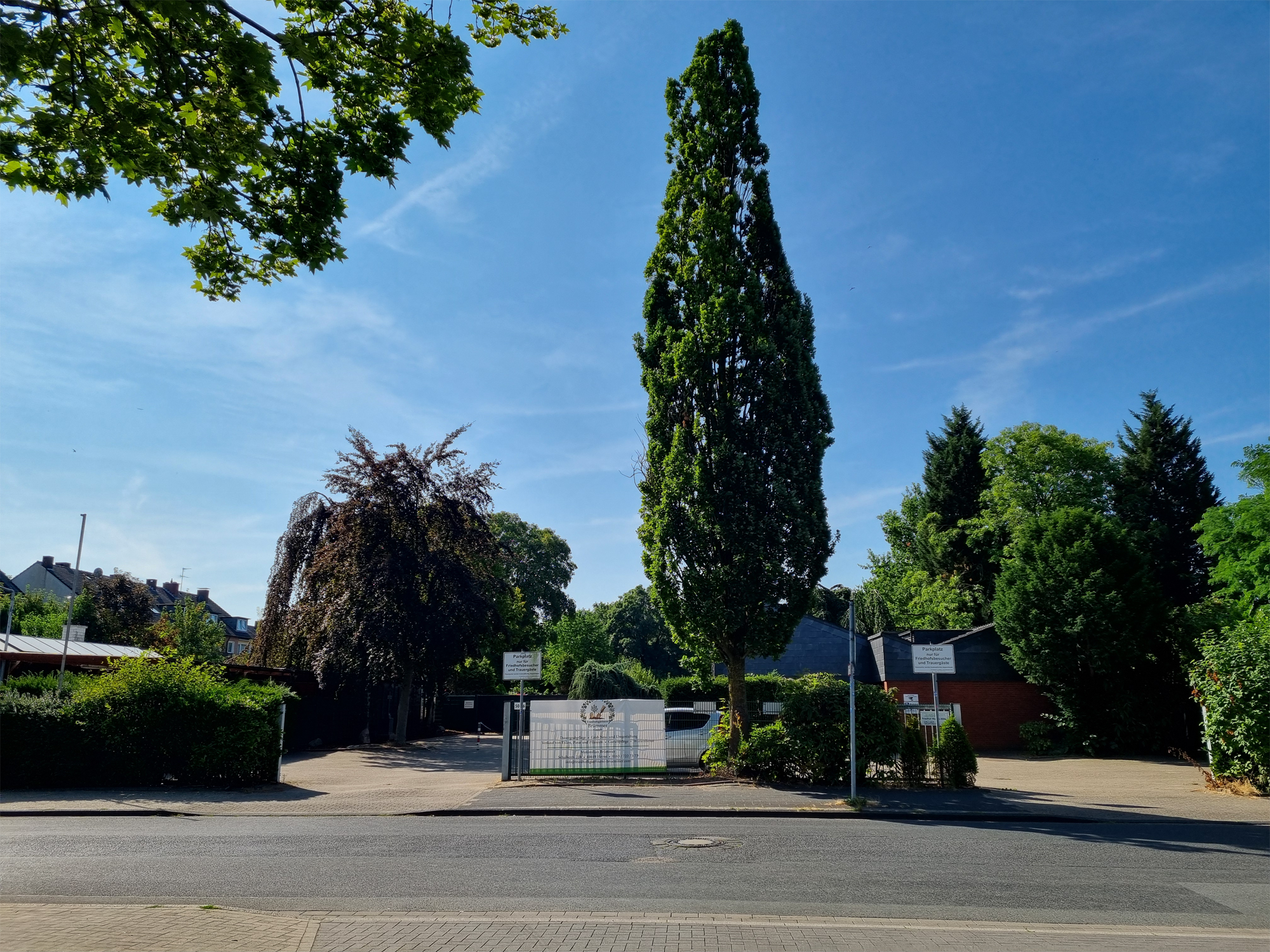 Blick über die Claudiusstraße auf den Parkplatz und die Trauerhalle.