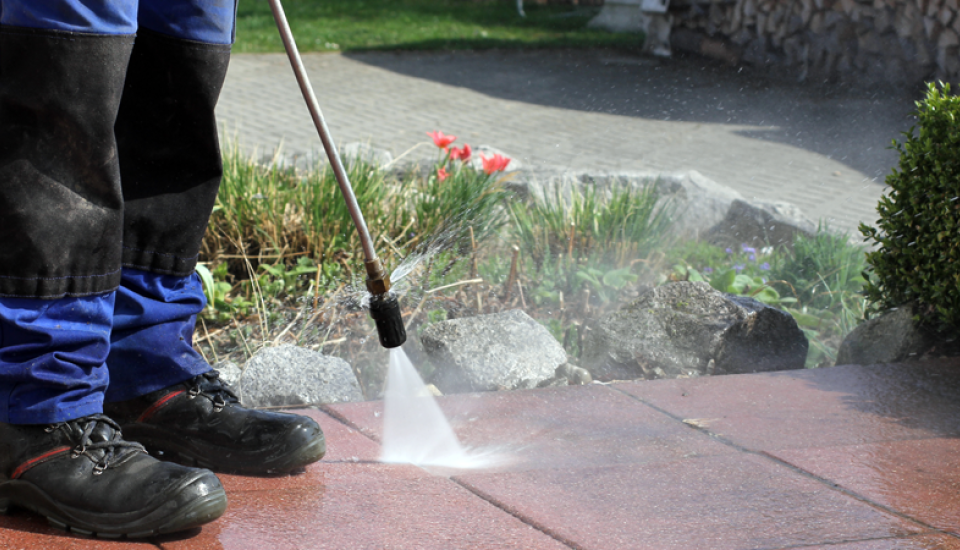 Reinigung von Terrassenplatten mit einem Hochdruckreiniger und hartem Wasserstrahl.
